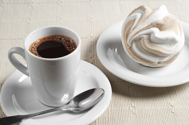 Tasse heißen Kaffee und Marshmallow auf Tischdecke