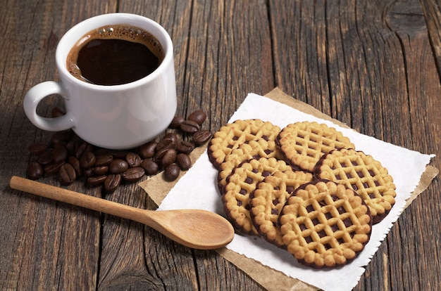 Tasse heißen Kaffee und runde Kekse mit Schokolade