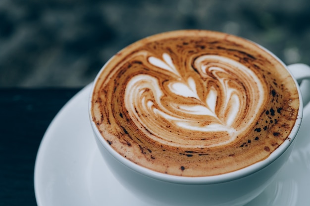 Tasse heißen Latte Art Kaffee auf Holztisch