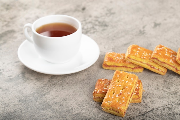 Tasse heißen Tee mit knusprigen Keksen mit Sesam.