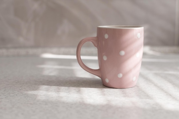 Tasse in der Sonne in der Küche auf einem grauen Tisch