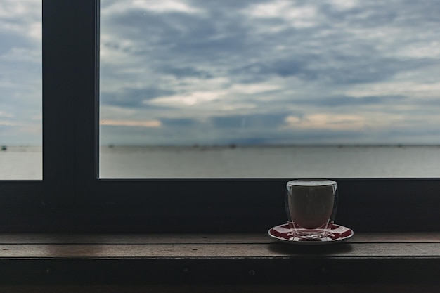 Tasse Kaffee an der Bar mit abendlichem Meerblick