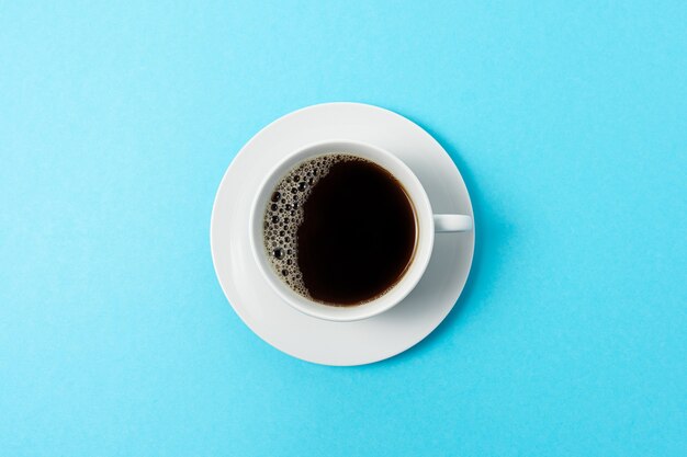 Tasse Kaffee auf blauem Hintergrund.