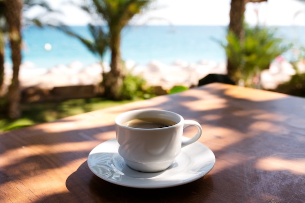 Tasse Kaffee auf dem Hintergrund des Ozeans