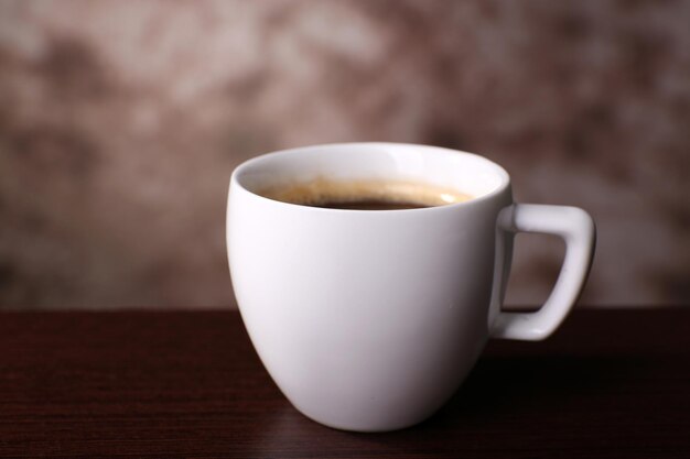 Tasse Kaffee auf dem Tisch in der Nähe