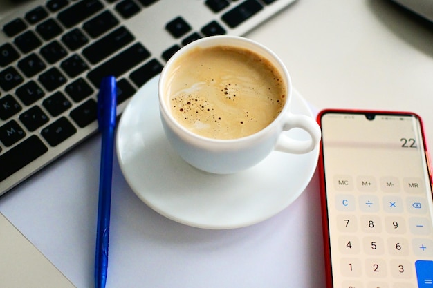 Tasse Kaffee auf dem Tisch mit Laptop