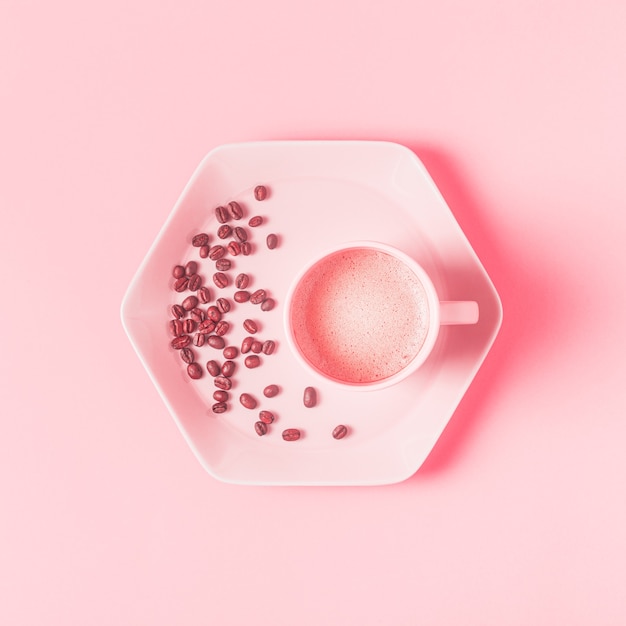 Tasse Kaffee auf einem rosa Pastellhintergrund. Flache Lage, Draufsicht.
