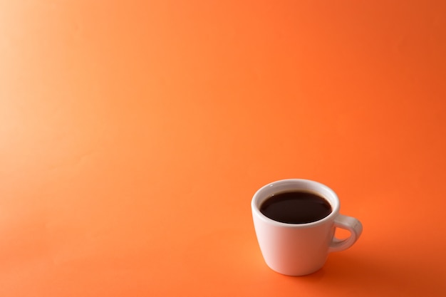 Tasse Kaffee auf orange Hintergrund