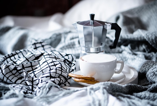 Tasse Kaffee auf Tablett im gemütlichen Winterbad mit Wolldecke