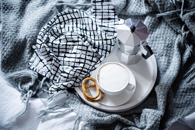 Tasse Kaffee auf Tablett im gemütlichen Winterbad mit Wolldecke