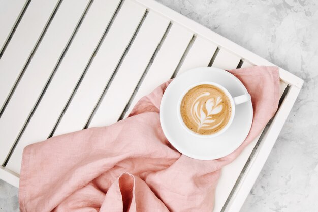 Tasse Kaffee auf weißem Holztablett