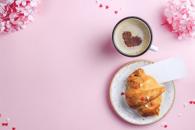 Tasse Kaffee, Croissant auf rosa Hintergrund mit leerer Karte