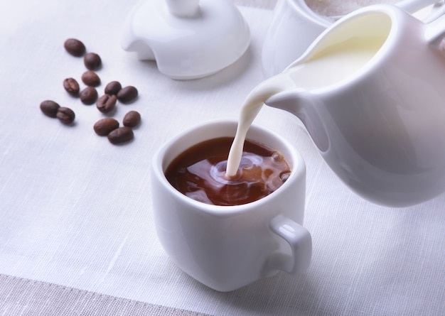 Tasse Kaffee Espresso, Krug Milch und Schüssel mit Zucker.