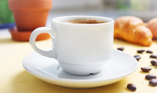 Tasse Kaffee, frische Croissants auf dem Tisch. Traditionelles Frühstück. Guten Morgen.