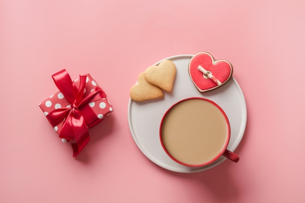 Tasse Kaffee, Geschenk und Kekse in Form des Herzens. Valentinstag Kekse mit Liebesbrief. Flache Lage, Kopierraum