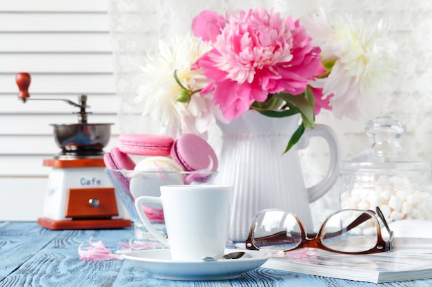 Tasse Kaffee, Kekse und Blumen auf dem Tisch