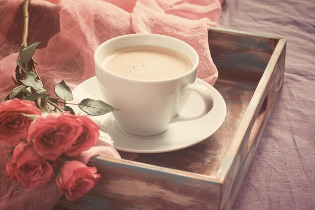 Tasse Kaffee, Kekse und Rose. Konzept des Valentinstagsfrühstücks, Tonisierung in Pastellfarben