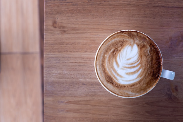 Tasse Kaffee Latte auf hölzerner Tabelle.