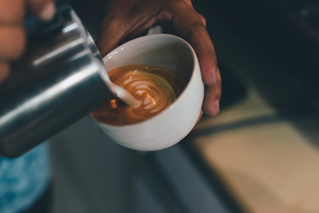 Foto tasse kaffee lattekunst auf dem hölzernen schreibtischcafé-café