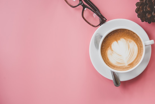 Tasse Kaffee Lattekunst Herzform mit Kopienraum auf rosa Tabelle