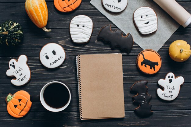 Tasse Kaffee, Lebkuchen für Halloween, Notebook und Kürbisse.