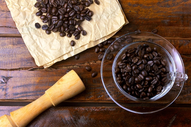 Tasse Kaffee lokalisiert mit den gebratenen und frischen Bohnen auf rustikalem Holztisch