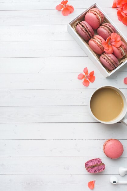 Tasse Kaffee, Makronenplätzchen in einem Kasten, Blumen mit Kopienraum