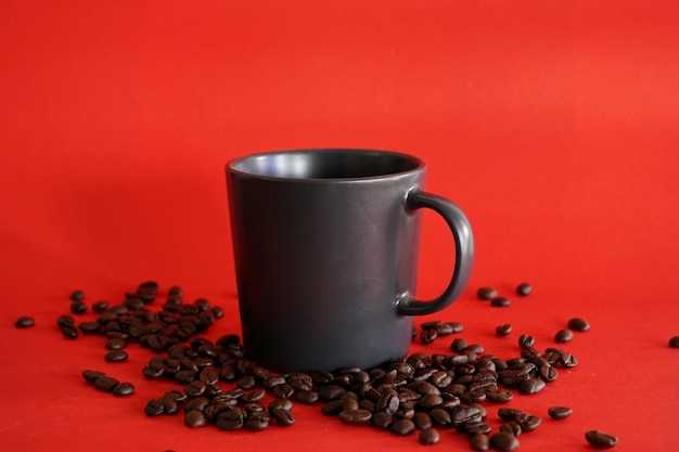 Tasse Kaffee mit Bohnen auf rotem Hintergrund