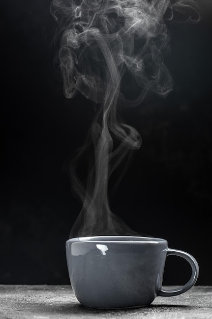 Foto tasse kaffee mit dampf auf schwarzem hintergrund heißes getränk heißer dampf mit rauch kulinarisches kochkonzept