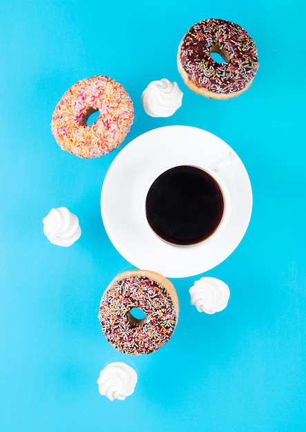 Tasse Kaffee mit Donuts und Meringues in Bewegung