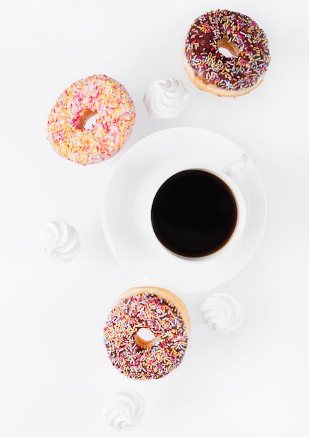 Tasse Kaffee mit Donuts und Meringues in Bewegung