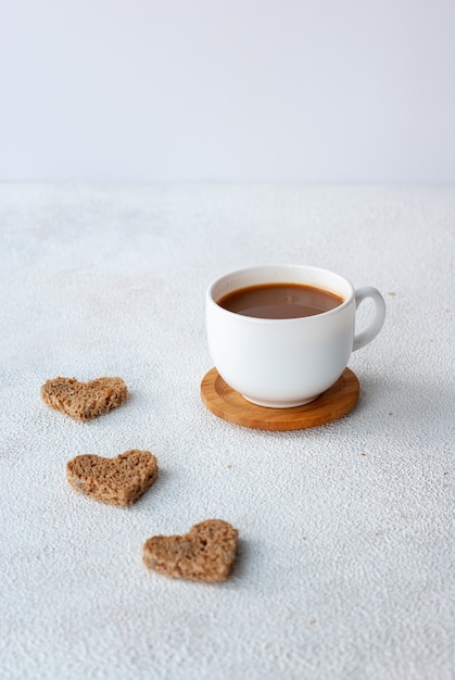 Tasse Kaffee mit drei Stücken Herz-Shapet-Brot