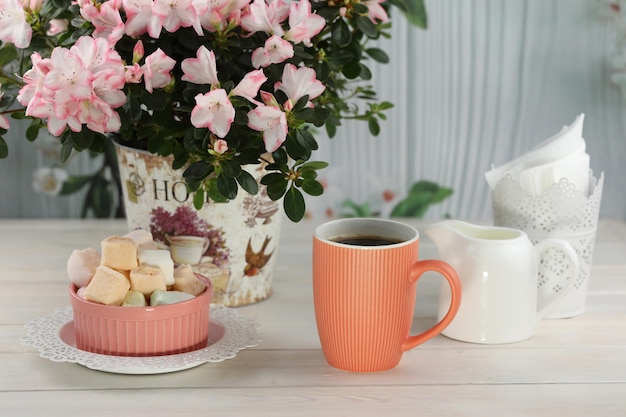 Tasse Kaffee mit Eibisch auf weißem Holztisch