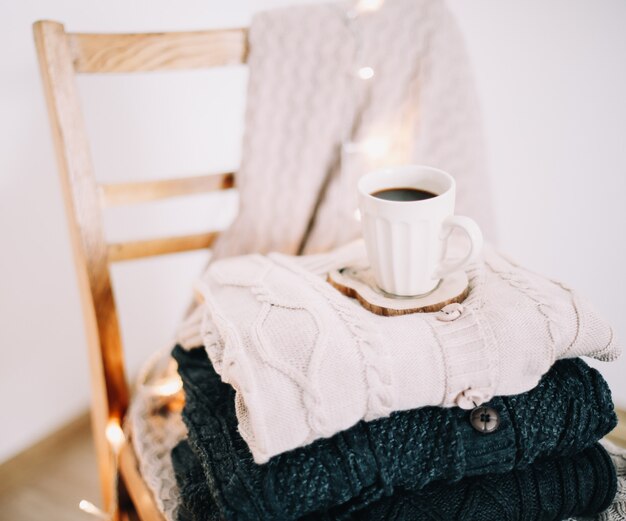 Tasse Kaffee mit einem gestrickten beige Plaid im Hintergrund Herbst und Winter gemütliches Freizeitkonzept