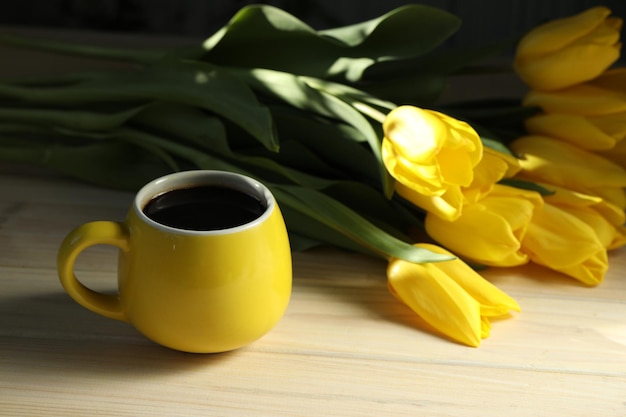 Tasse Kaffee mit gelben Tulpen