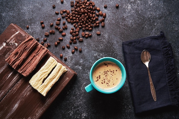 Tasse Kaffee mit gerösteten Kaffeebohnen und Schokoladenhintergrund