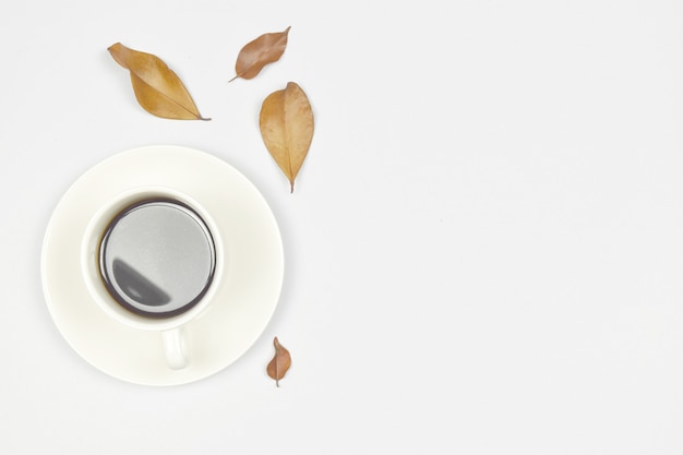 Tasse Kaffee mit Herbstblatt auf Weiß. Kopieren Sie Platz.