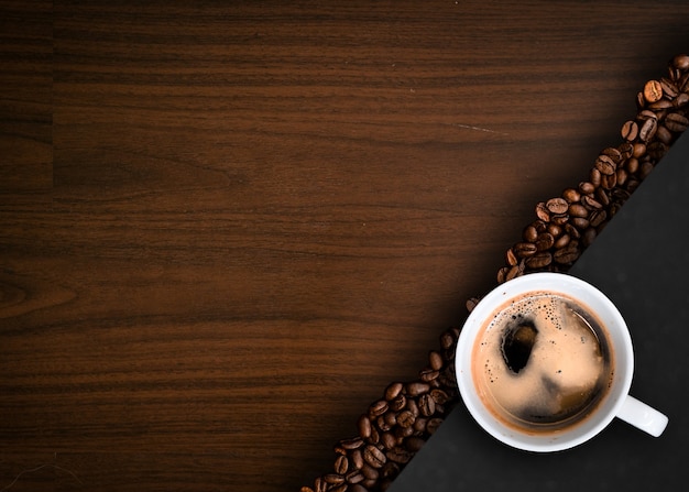 Tasse Kaffee mit Kaffeebohnen auf dem Tisch