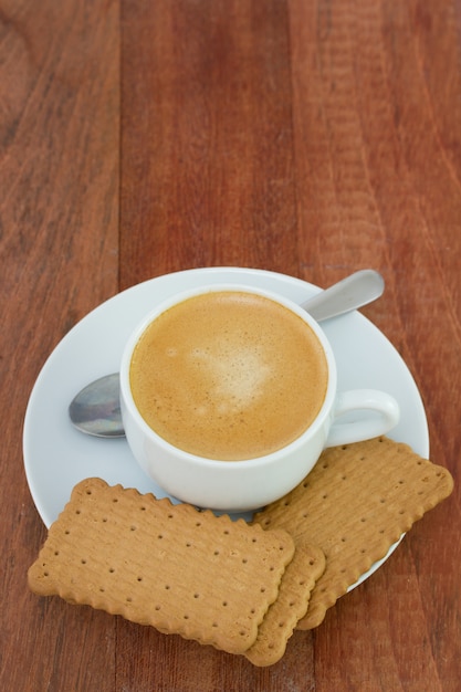 Tasse Kaffee mit Keksen und Löffel