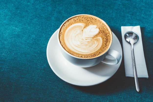 Tasse Kaffee mit Lattekunst auf Tabelle