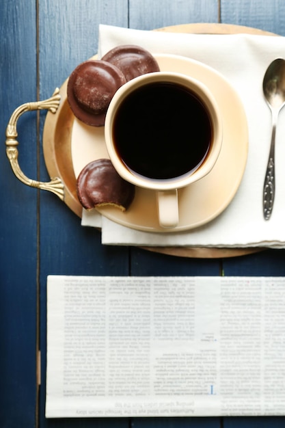 Tasse Kaffee mit leckeren Keksen auf farbigem Holzhintergrund