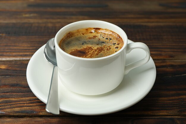 Tasse Kaffee mit Löffel auf hölzernem Hintergrund, Raum für Text und Nahaufnahme