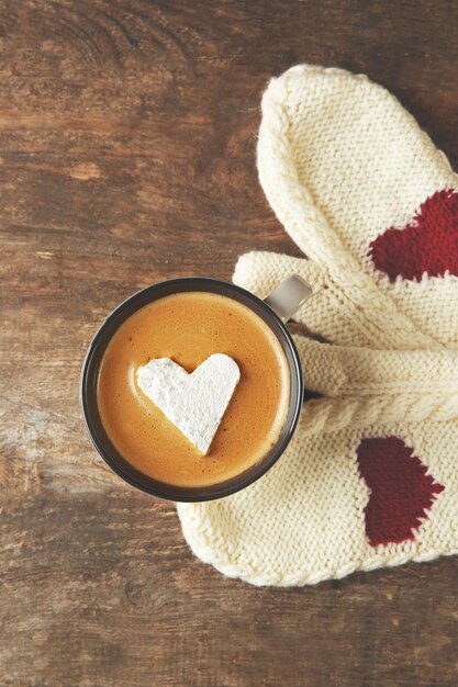 Tasse Kaffee mit Marshmallow auf Holztisch