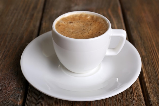 Tasse Kaffee mit Milch auf hölzernem Hintergrund
