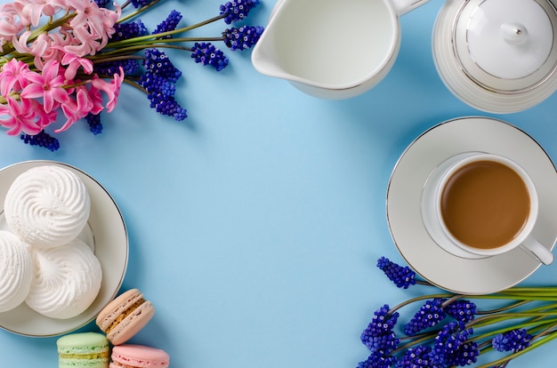 Tasse Kaffee mit Milch, weiße Meringues, Macarons, Milchglas