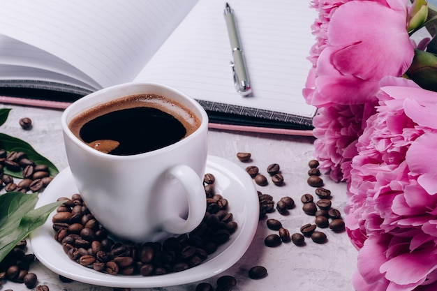 Foto tasse kaffee mit pfingstrosen auf dem tisch