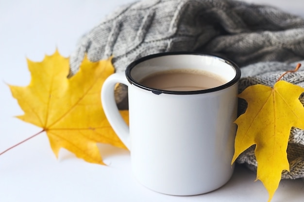 Tasse Kaffee mit Pullover und Herbstlaub