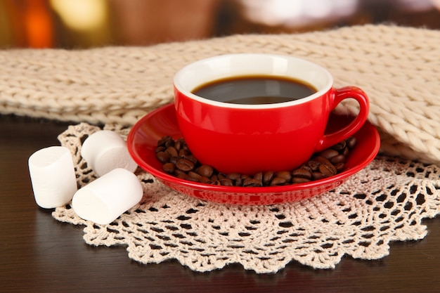 Tasse Kaffee mit Schal auf dem Tisch im Zimmer