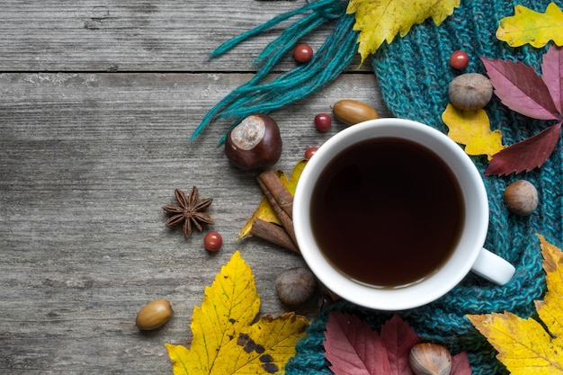 Tasse Kaffee mit Schal und Herbstlaub