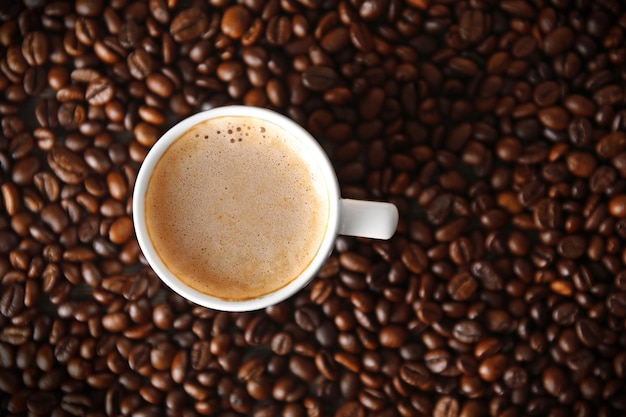 Tasse Kaffee mit Schaum über den Körnern, Draufsicht